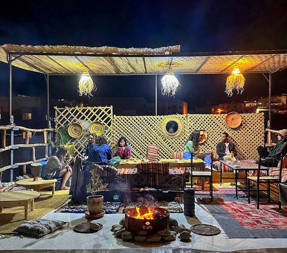 Guests gathered around the rooftop fire bowl in the evening
