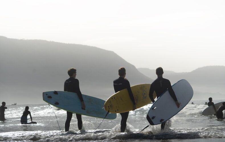 Surfers walking into the Atlantic with their boards at first light